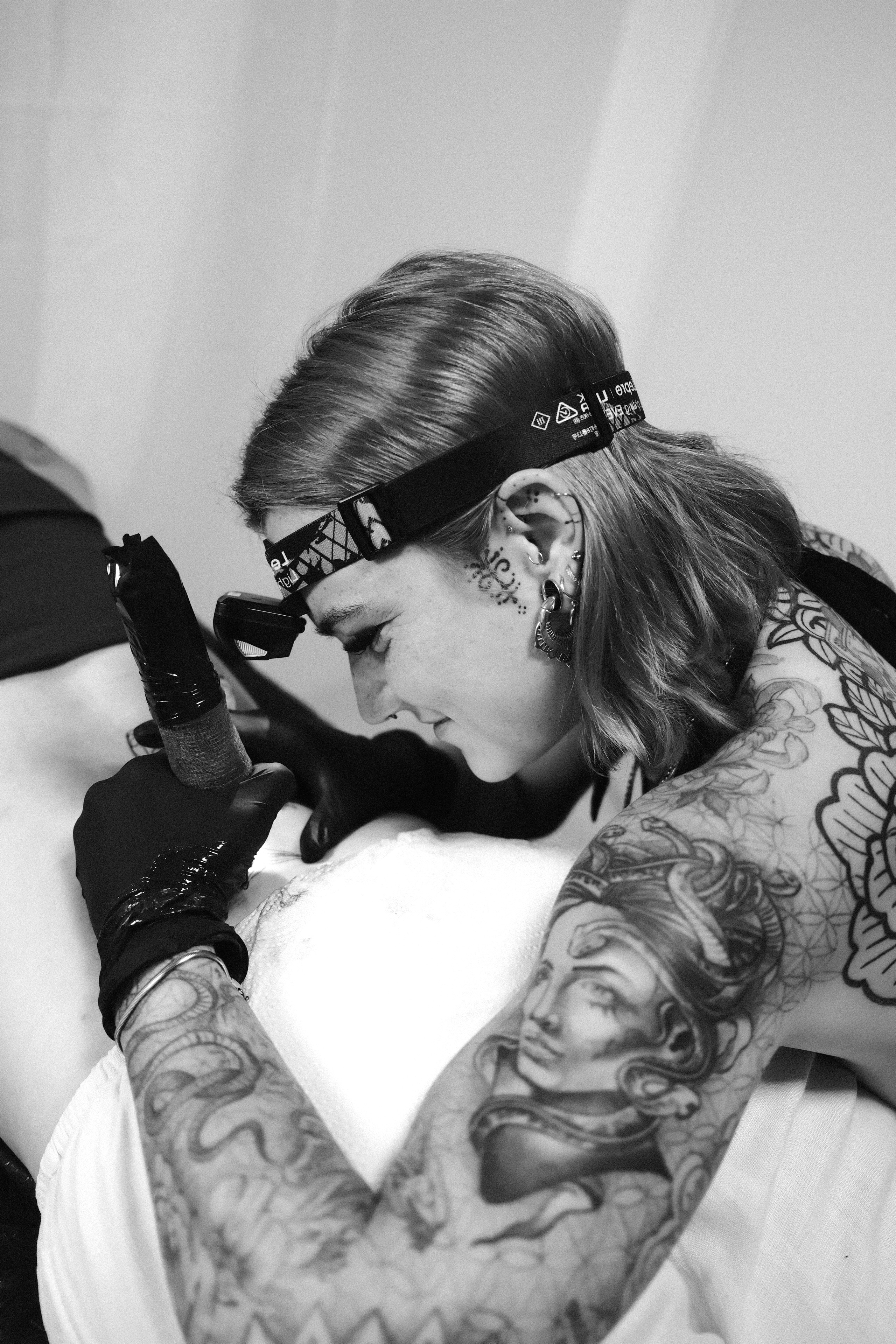 Ich tätowiere konzentriert an einem Rückenmotiv.